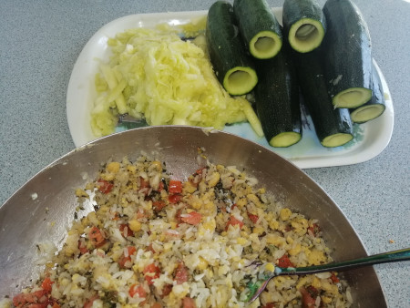 Stuffed courgettes and vine leaves_preparation Cored courgettes and a pan with rice and vegetables